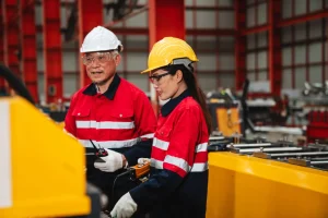 Inspectores de seguridad industrial con casco y equipo de protección realizando auditoría de cumplimiento social SMETA. 