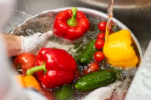 Operario realizando lavado de alimentos como parte de controles de inocuidad y evaluación en una matriz de riesgos BRCGS.