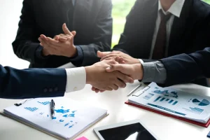 Manos estrechándose como símbolo del compromiso con la responsabilidad social en las empresas y las auditorías de comercio ético.